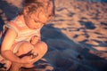 Curious child girl toddler portrait playing on beach with hermit crab during summer vacation concept childhood lifestyle