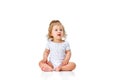 Curious child. Little, cute baby girl, toddler in diaper sitting on floor and attentively looking against white studio Royalty Free Stock Photo