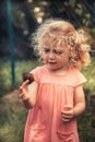 Curious child toddler with disgust emotion holding snail concept childhood curiosity lifestyle