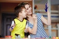 Curious childhood, a little boy playing with his mother, draws, paints on the palms. Royalty Free Stock Photo