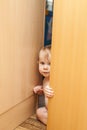 Curious cute baby boy looking through ajar door Royalty Free Stock Photo