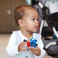 Curious cute toddler boy in suit with bowtie playing with toy care