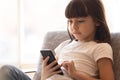 Little smart kid holding smartphone playing game online at home Royalty Free Stock Photo