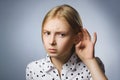 Curious Disappointed girl listens. Closeup portrait child hearing something, parents talk, hand to ear gesture