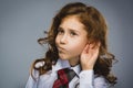 Curious Disappointed girl listens. Closeup portrait child hearing something, parents talk, hand to ear gesture isolated