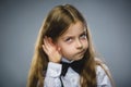 Curious Disappointed girl listens. Closeup portrait child hearing something, parents talk, hand to ear gesture isolated