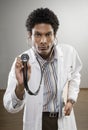 Curious doctor in lab coat holding stethoscope Royalty Free Stock Photo