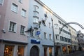 Curious facade climber on a house front as shop advertising in the Bruneck pedestrians zone, Bruneck, Italy