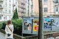 Curious French woman walking near the political posters campaign advertising in