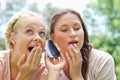 Curious friends listening to phone call in the park