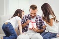 Curious girls looking at father opening gift Royalty Free Stock Photo