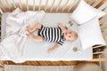 Curious infant baby lying in crib and chewing his finger Royalty Free Stock Photo