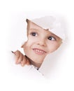 Curious kid looks through a hole in white paper Royalty Free Stock Photo