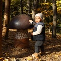 Curious kid playing with giant wooden mushroom Royalty Free Stock Photo