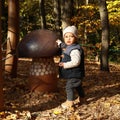 Curious kid playing with giant wooden mushroom Royalty Free Stock Photo