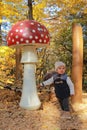 Curious kid playing with giant wooden mushroom Royalty Free Stock Photo