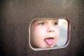 Curious kid spying through the hole in the wooden wall on playground Royalty Free Stock Photo