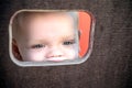 Curious kid spying through the hole in the wooden wall on playground Royalty Free Stock Photo