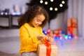 Curious little black girl opening gift box on Christmas Eve Royalty Free Stock Photo