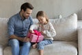 Curious little girl unpacking wrapped gift box.