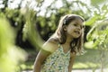 Curious little girl in the countryside among green plants - concept of childhood, sustainability, ecology, green economy and clean