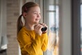 Curious little girl with Down syndrome with binoculars looking through window at home. Royalty Free Stock Photo