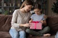 Smiling young mum congratulating small child daughter at home. Royalty Free Stock Photo