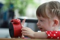 Curious little pretty girl explore red clock touch dial with finger