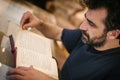 Curious man reading old book in his library at home Royalty Free Stock Photo