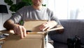 Curious man unboxing unpacking Amazon on living room sofa Royalty Free Stock Photo