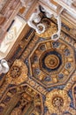 Curious marble sculptures decorating luxurious ceiling of italian palace