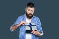 curious mature bearded man with present box on grey background