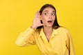 Curious Millennial Woman Listening Secrets Eavesdropping Posing Over Yellow Background Royalty Free Stock Photo