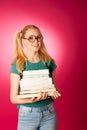 Curious, naughty, playful schoolgirl with stack of books and big