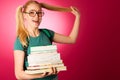 Curious, naughty, playful schoolgirl with stack of books and big