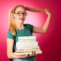 Curious, naughty, playful schoolgirl with stack of books and big