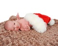 Curious newborn laying in Santa hat on blanket