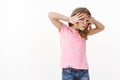 Curious and nosy cute little girl with blond hair, hiding face with palms, look through fingers intrigued, stare camera Royalty Free Stock Photo