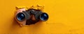 The Curious Observer Peering Through a Hole with Binoculars on a Yellow Wall AI generated image Royalty Free Stock Photo
