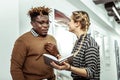 Curious positive lady asking her workmate for advice