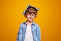 Curious pupil with textbook on head Royalty Free Stock Photo