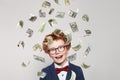 Curious redhead little kid boy with us dollar money rain on white background Royalty Free Stock Photo