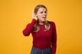 Curious shocked young blonde woman girl in casual clothes posing isolated on yellow orange background studio portrait