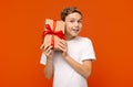 Curious teen boy checking gift, shaking present box