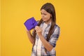 curious teen girl with birthday gift isolated on yellow. teen girl celebrating birthday with present in studio. teen