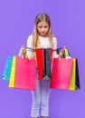 curious teen girl with shopping purchase isolated on purple. teen girl with shopping purchase