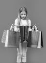 curious teen girl with shopping purchase isolated on purple. teen girl with shopping purchase