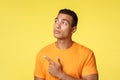 Curious, thoughtful young handsome man choosing fast food, want eat something unhealthy, thinking, pointing and looking Royalty Free Stock Photo