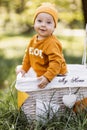 Curious toddler standing inside wicker basket on fresh air