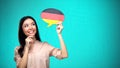 Curious woman holding German flag sign, learning language, education abroad